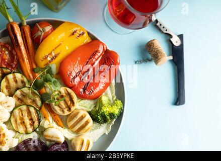 Gegrilltes Gemüse aus biologischem Anbau, Paprika, Blumenkohl, Brokkoli, Karotten, Pilze und rote Zwiebeln auf einem runden Teller. Vegetarisches Abendessen, serviert von RO Stockfoto