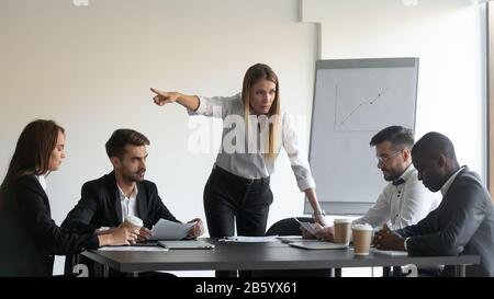 Verärgerter weiblicher Teamleiter, der den Mitarbeiter zum Verlassen auffordert. Stockfoto