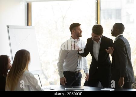 Tausende von Geschäftsleuten setzen zwei aggressive multirassische Mitarbeiter auseinander. Stockfoto