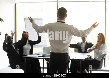 Rückansicht junger Teamleiter mit erhobenen Händen. Stockfoto