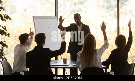 Emotional gebendes junges Business-Team trifft einstimmige Entscheidungen beim Brainstorming-Meeting. Stockfoto