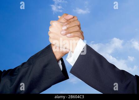 Die Hand schütteln zwischen einem Unternehmer und eine Geschäftsfrau Himmel Hintergrund Stockfoto