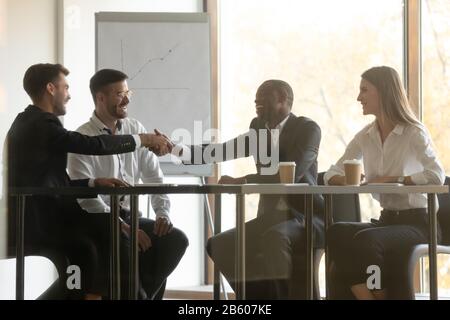 Multirassische Partner halten Verhandlungssitzung im Büro ab. Stockfoto