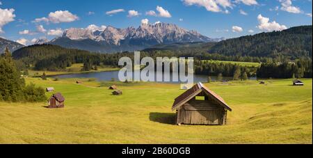 Panoramalandschaft mit Wiese und See vor den alpen Stockfoto