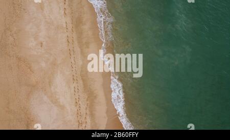 Ein Natur-Drone-Shoot mit Blick auf die Natur zeigt ein atemberaubendes farbiges Meer, kristallklares Wasser und Sand an der Algarve, Portugal Stockfoto