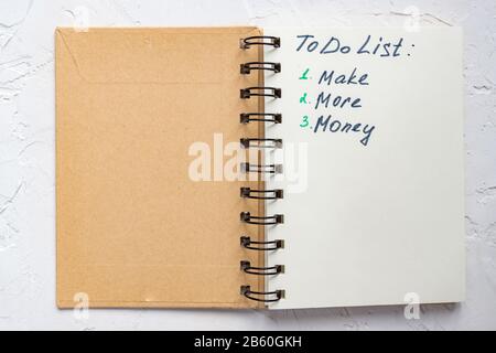 To-DO-Liste - verdienen Sie mehr Geld, wenn Sie Text auf dem Notizblock schreiben. Nahaufnahme. Stockfoto