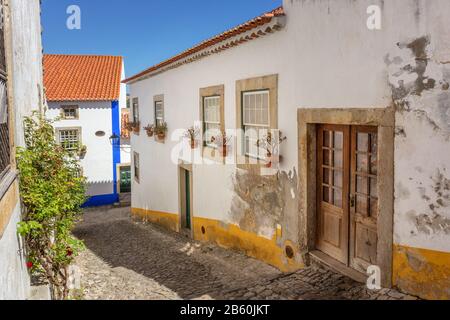 Das historische portugiesische Dorf Obidos und enge Gassen mit Kopfsteinpflaster. Stockfoto