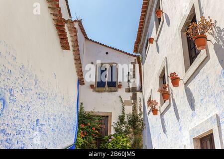 Das historische portugiesische Dorf Obidos und enge Gassen mit Kopfsteinpflaster. Stockfoto
