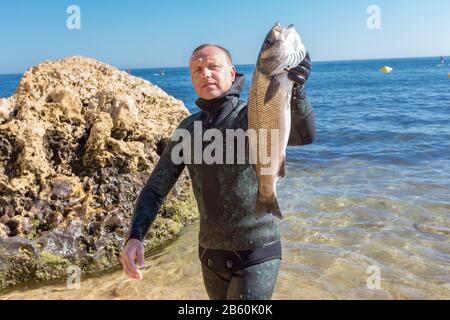 Unterwasserjäger zeigt Fang. Portugiesische Robalo im Sommer Stockfoto