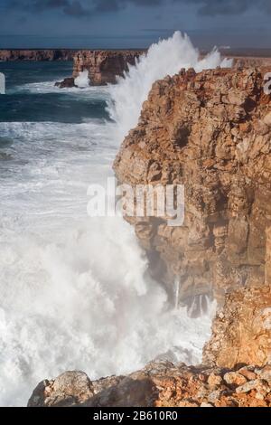 Spritzende Wellen schlagen gegen die Felsen. Sagres in Portugal. Stockfoto