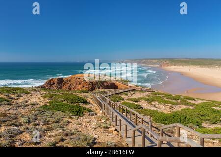 Holzsteg zum Strand Praia da Amoreira, Distrikt Aljezur, Algarve Portugal Stockfoto