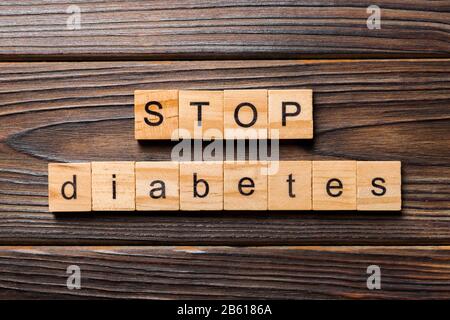 Stoppen Sie das Wort Diabetes, das auf Holzblock geschrieben wurde. Stoppen Sie den Diabetes-Text auf dem Holztisch für Ihr Desing, Top-View-Konzept. Stockfoto