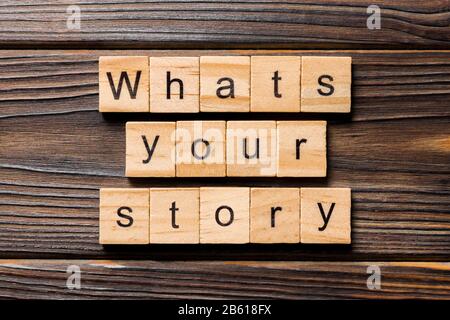 Was ist Ihr Geschichtenwort, das auf Holzklotz geschrieben wurde. Was ist Ihr Geschichtentext auf Holztisch für Ihr Desing, Top-View-Konzept. Stockfoto