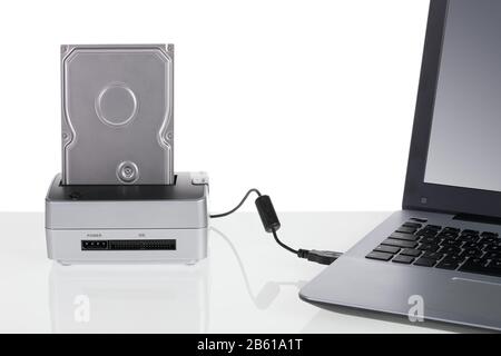 Festplatte mit Docking-Station, die an einen Laptop-Computer angeschlossen ist. Zur Datenspeicherung. Stockfoto