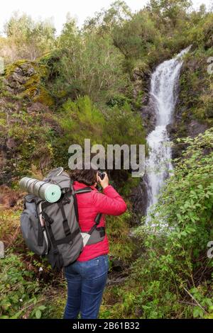 Mädchen Tourist fotografiert einen Wasserfall. In Portugal das Dorf Monchique. Stockfoto