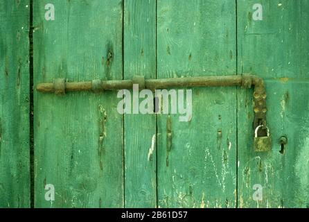 Handgefertigte Beschläge auf einer alten hölzernen, bemalten, grünen Tür in Metsovo, Ioannina, Epirus, Griechenland Stockfoto