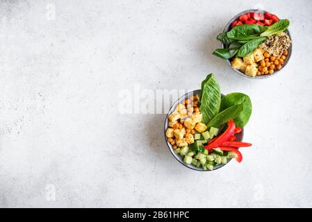 Vegane Mittagsschüssel, ausgewogene, gesunde buddhaschüssel. Gebratene Tofu, Quinoa, Kichererbse, Gurke, Romane, Paprika, Samen und Grüngemüse Salat, Stockfoto