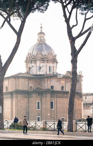 Roma, Italien, 27.11.2019: Touristen mit Kirche der Heiligen Luca und Martina in den kaiserlichen Foren in Rom, Reisereportage Stockfoto