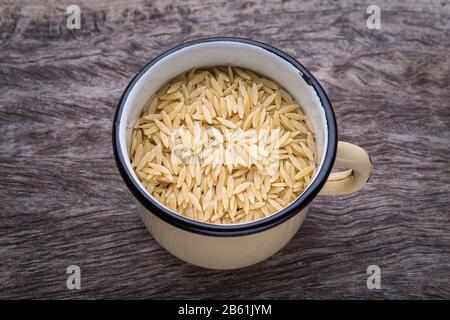 Lange Pasta aus Reis im alten Eisbecher. Auf Holzstruktur. Stockfoto