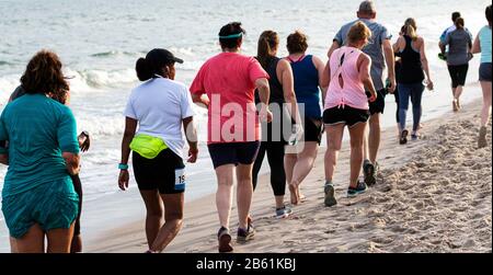 Babylon, New York, USA - 24. Juni 2019: Hunderte von Menschen laufen und gehen ein 1,5-km-Rennen am Strand neben dem Meereswasser, als Teil des Ne Stockfoto