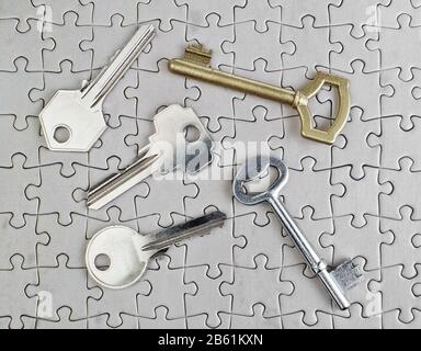 Schlüssel verschiedener Arten von Puzzles auf einer Nahaufnahme aus Gold und Silber. Stockfoto