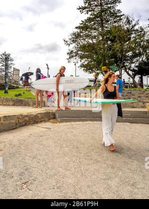 Zwei kaukasische Frauen, die Surfbretter zum Strand am Cottesloe Beach Perth WA Australia tragen Stockfoto