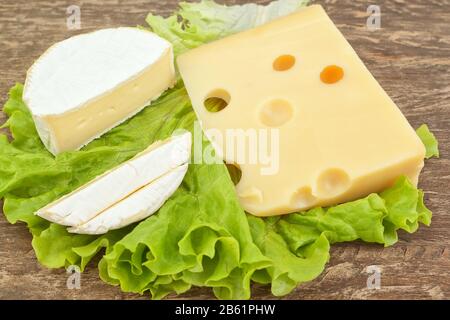 Snack auf einem Holztisch aus zwei Käsesorten auf einem Salat. Stockfoto