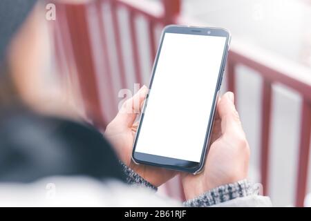 Smartphone mit weißem Bildschirm in der Hand. Frau hält ein Handy. Stockfoto