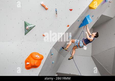 Mai 2017, UFA, RUSSLAND: Ein Mann klettert auf eine künstliche offene Felswand mit niedrigerem Belay Stockfoto