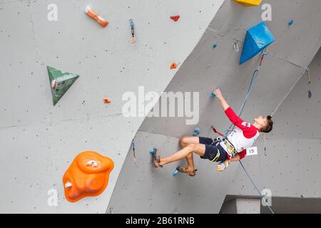 Mai 2017, UFA, RUSSLAND: Ein Mann klettert auf eine künstliche offene Felswand mit niedrigerem Belay Stockfoto