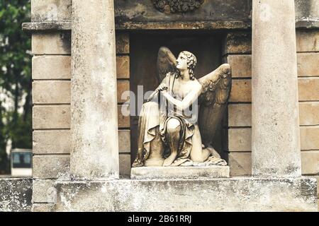 Alte, zerstörte und überwucherte Denkmäler auf Gräbern auf dem Wiener Zentralfriedhof, Begriff der Trauer und Tragödie Stockfoto