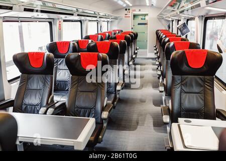Leere Ledersitze erwarten die Passagiere im luxuriösen und modernen Zug Stockfoto