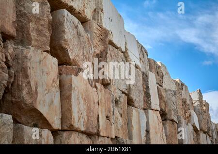 Detail eines Teils einer Mauer aus Marmorsteinen, die in einem Steinbruch geschnitten und abgebrochen wurde Stockfoto