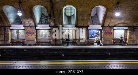 London, England, Großbritannien - 3. März 2020: Pendler warten auf den Bahnsteigen der histoischen Station Baker Street der London Underground. Stockfoto