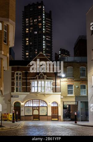 London, England, Großbritannien - 25. Februar 2020: Der hohe Brutalist Lauderdale Tower des Barbica-Anwesens ragt über Büros im traditionellen Tiefhaus Cle Stockfoto