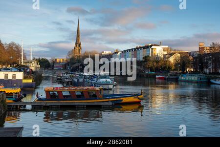 Bristol, England, Großbritannien - 29. Dezember 2019: Abendsonne scheint auf dem Turmspitze der St. Mary Redcliffe Kirche und der historischen Docks von Bristol. Stockfoto