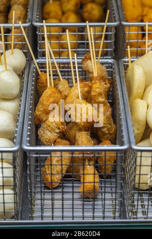 Nahaufnahme von frittierten Fisch-Kugelspießern am Lebensmittel-Stall Stockfoto