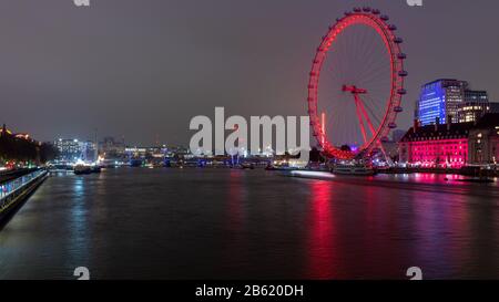 London, England, Großbritannien - 21. November 2019: Das London Eye und die Brücken der Themse werden nachts im Zentrum Londons angezündet. Stockfoto