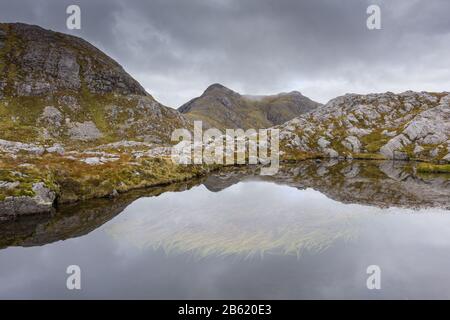 Hochlandlochan mit schwimmendem Bur-Reed (Sparganium angustifolium) in der Nähe von Garbh Bheinn, Ardgour, Schottland Stockfoto