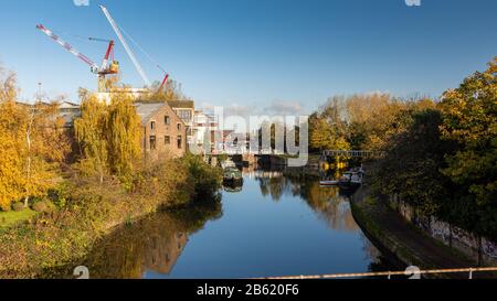 London, England, Großbritannien - 18. November 2019: Herbstsonne auf dem Fluss Lea Navigation und Lichtindustriegebäude und neue Bauwohnungen in der Fi Stockfoto