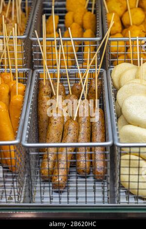 Frittierte Wurst- und Nuggespieße auf dem Straßennahrungsmarkt Stockfoto