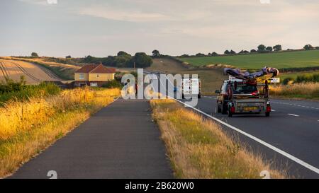 Dorchester, England, Großbritannien - 21. Juli 2018: Radfahrer fahren auf einem getrennten Radweg neben dem Verkehr auf der A354 Dorchester-Weymouth Road in Dorset. Stockfoto