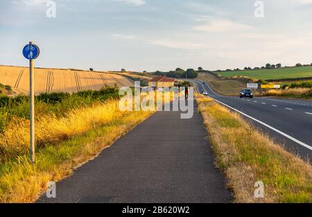 Dorchester, England, Großbritannien - 21. Juli 2018: Radfahrer fahren auf einem getrennten Radweg neben dem Verkehr auf der A354 Dorchester-Weymouth Road in Dorset. Stockfoto