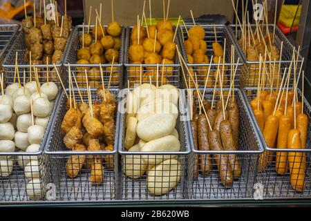 Verschiedene Fischball- und Wurstspieße im Straßenfood-Stall Stockfoto