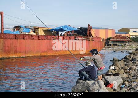 Makassar, Süd-Sulawesi, Indonesien. März 2020. Zwei Männer angeln am Strand in Makassar City, Provinz Süd-Sulawesi, Indonesien. Sie verbringen Zeit damit, um Losari Beach Credit zu angeln: Herwin Bahar/ZUMA Wire/Alamy Live News Stockfoto