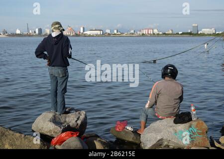 März 2020, Makassar, South Sulawesi, Indonesien: Zwei Männer angeln am Strand in Makassar City, Provinz Süd-Sulawesi, Indonesien. Sie verbringen Zeit damit, am Losari Beach zu angeln (Bild: © Herwin Bahar/ZUMA Wire) Stockfoto