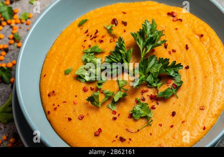 Indische Dhal würzige Curry in Schüssel, Gewürze, Kräuter, rustikaler grauer Holzhintergrund. Authentisches indisches Gericht. Makro Stockfoto