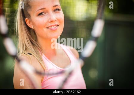 Hübsche, junge Frau Tennisspielerin, die auf einem Tonplatz spielt. Gesundes aktives Lifestyle-Konzept Stockfoto