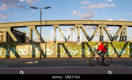 London, England, Großbritannien - 20. Juni 2016: Ein Radfahrer überquert die Hauptbahn der Westküste auf der Regent's Park Road in Camden im Norden Londons. Stockfoto