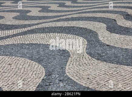 Schwarz-weißes Steinpflastermosaik in Lissabon, Portugal Stockfoto